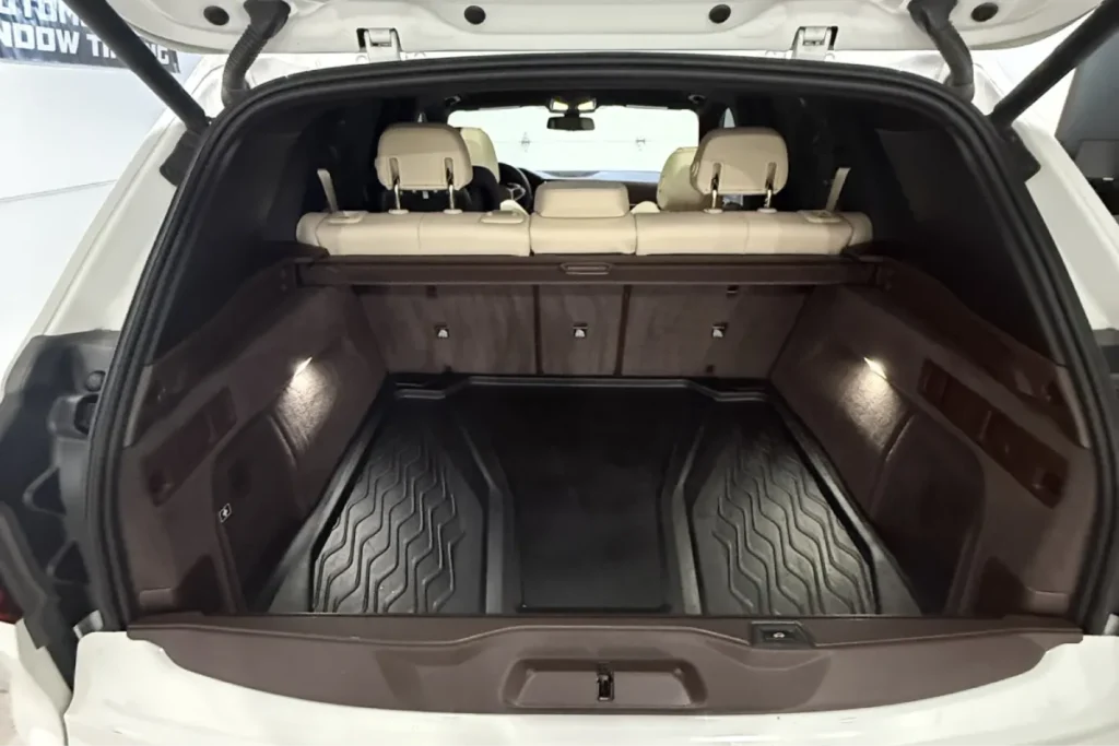 Spacious SUV trunk with a tan interior and rubber floor mats.