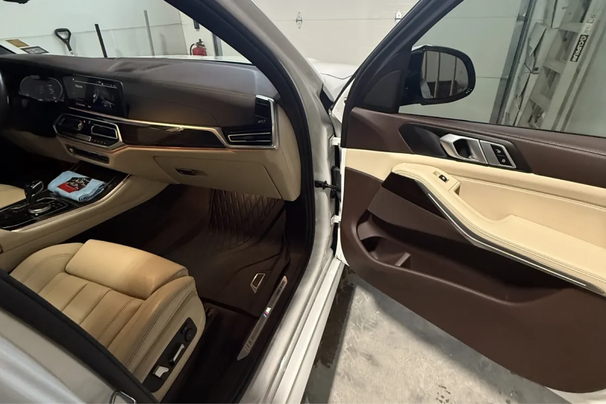 Luxurious car interior featuring tan leather seats and modern dashboard controls.