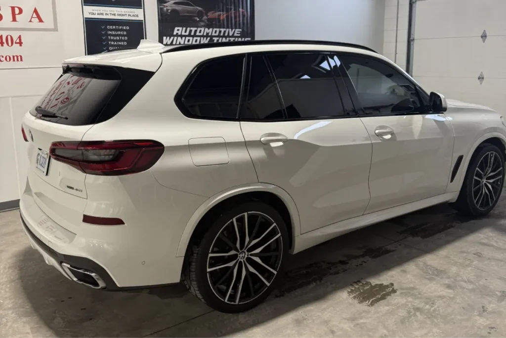 White BMW SUV with ceramic coating inside an auto detailing shop