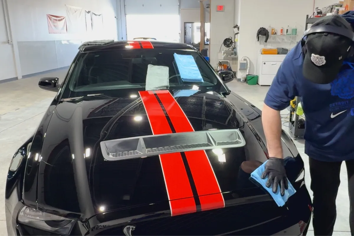 Professional paint correction restoring gloss on a black sports car.